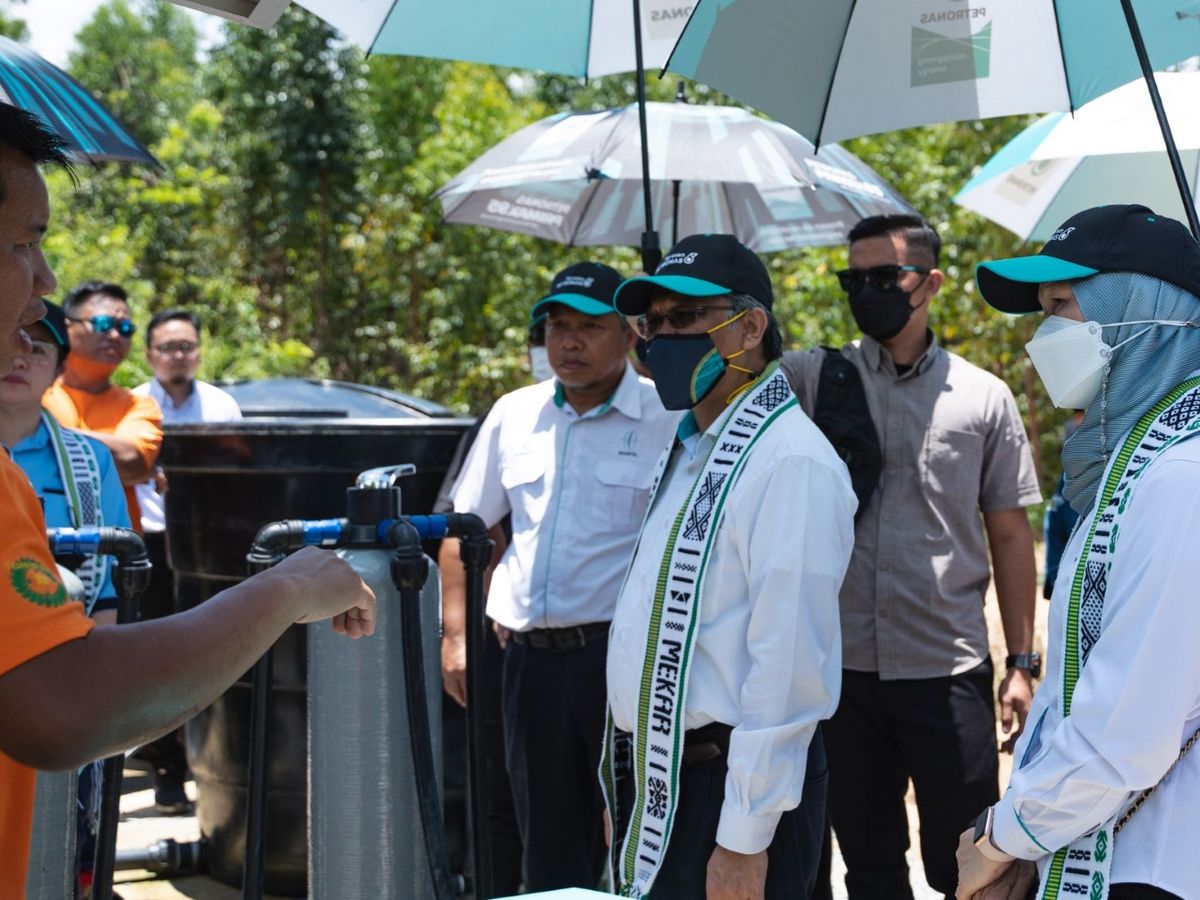 PETRONAS Senior Vice President of Project Delivery & Technology Bacho Pilong (centre), and Yayasan PETRONAS CEO Shariah Nelly Francis (right) receiving a briefing on the water supply system from a staff of Tonibung, the MEKAR programme implementation partner.