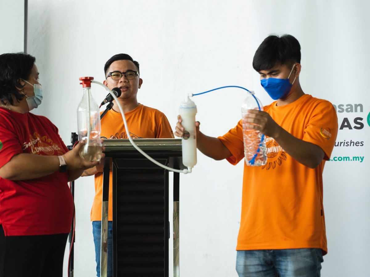Staff members of Tonibung, the implementation partner for the MEKAR programme, demonstrating the use of water filter during the MEKAR programme handover ceremony at Kampung Mangkapon Darat.