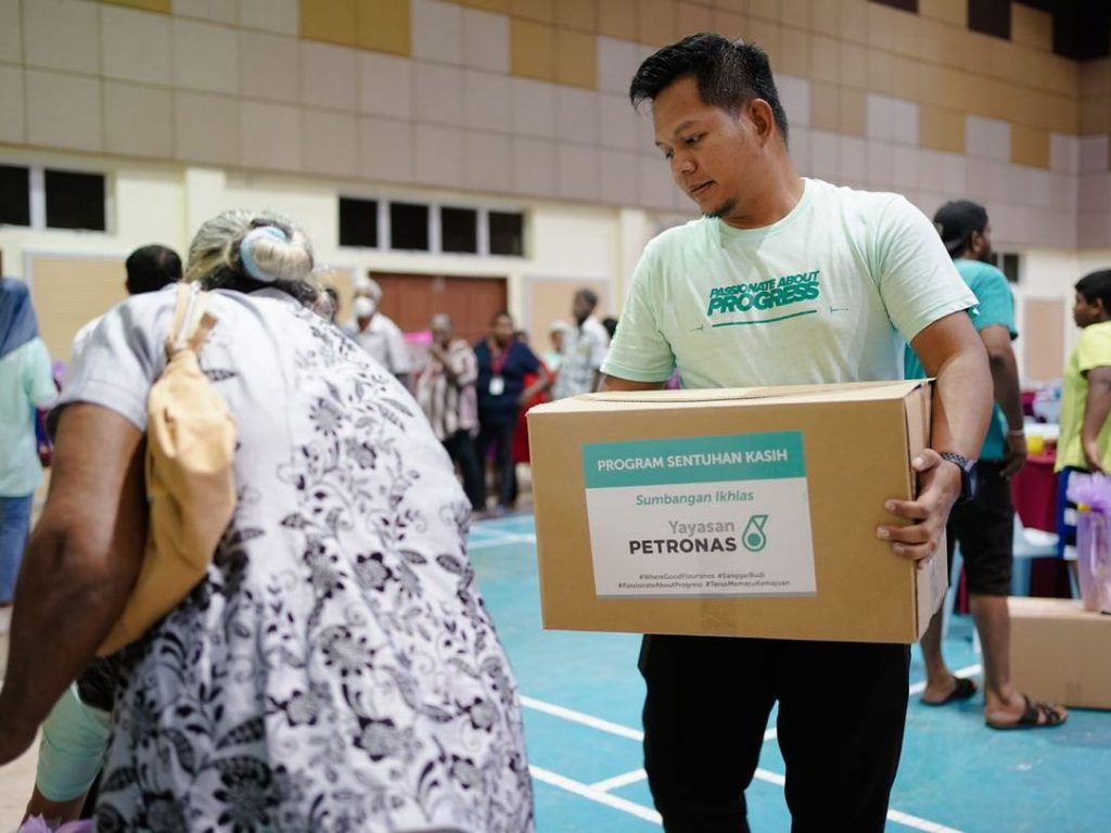 An employee from PETRONAS East Coast carrying contributions for beneficiaries in Pahang.