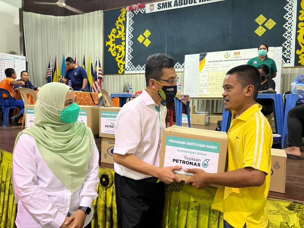 Zukifli Othman, Head of Northern and Central Region PETRONAS handing over an aid package to a flood vicitim in Perak.