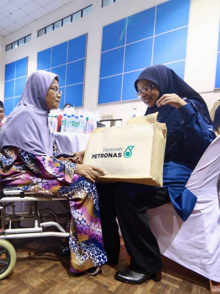 YB Hajah Aiman Athirah Sabu, Deputy Minister of Ministry of Women, Family, and Community Development handing over a food package to a beneficiary.